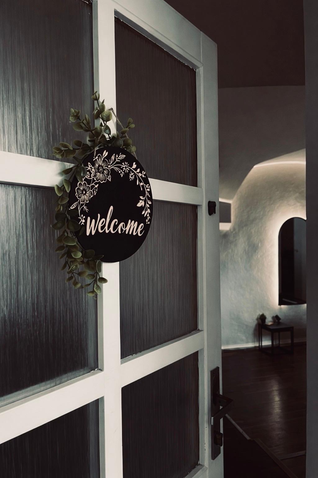 Vstupní dveře salonu s ceduli Welcome